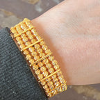 Al-Ruways 18k Pleated Gold Bracelet worn on a wrist, showcasing its elegant design and craftsmanship.