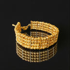 Al-Ruways 18k Pleated Gold Bracelet showcasing its elegant design and reflective surface.