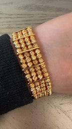 Al-Ruways 18k Pleated Gold Bracelet displayed on a wrist, showcasing its elegant design and gold craftsmanship.