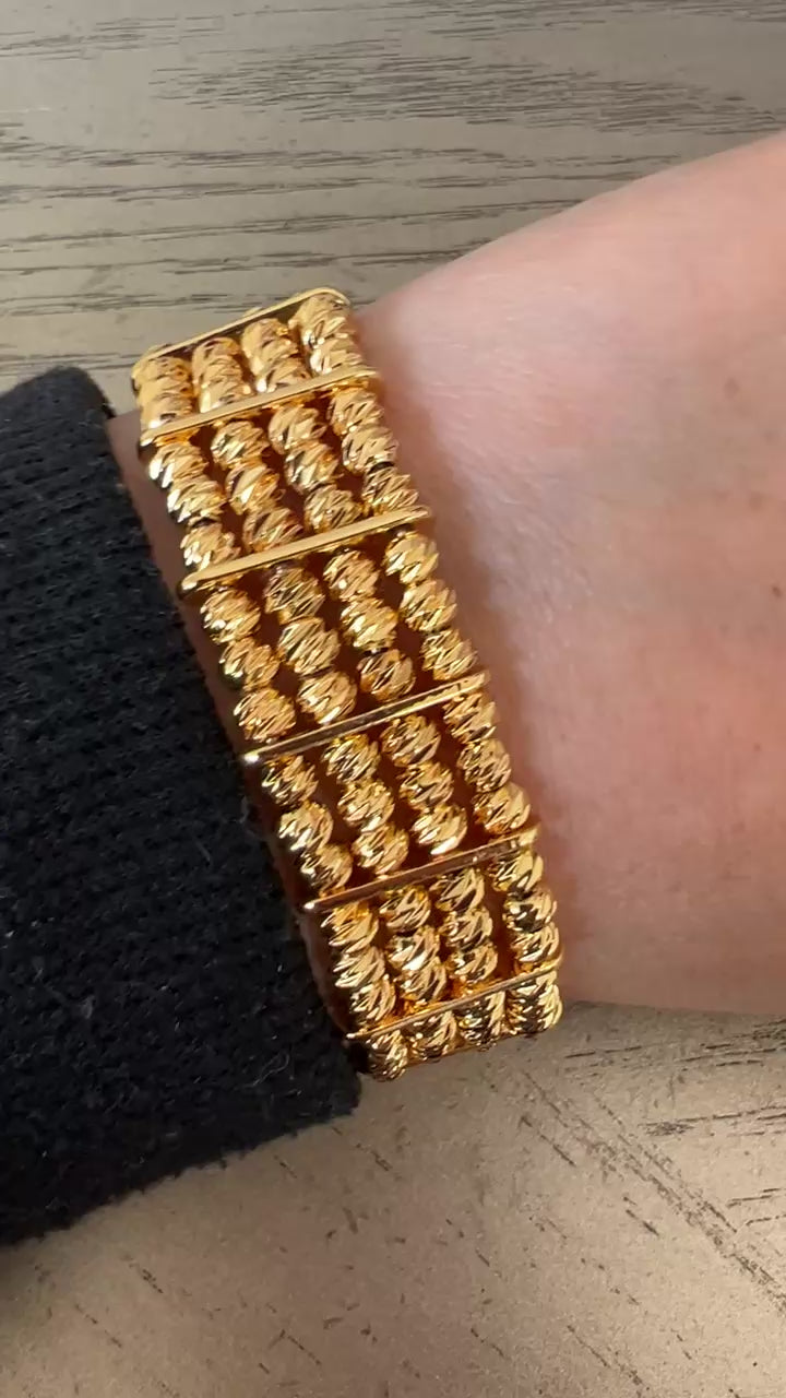 Al-Ruways 18k Pleated Gold Bracelet displayed on a wrist, showcasing its elegant design and gold craftsmanship.